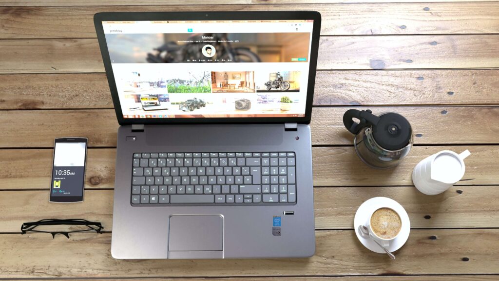 Un ordinateur, un téléphone, une tasse à café posés sur une table