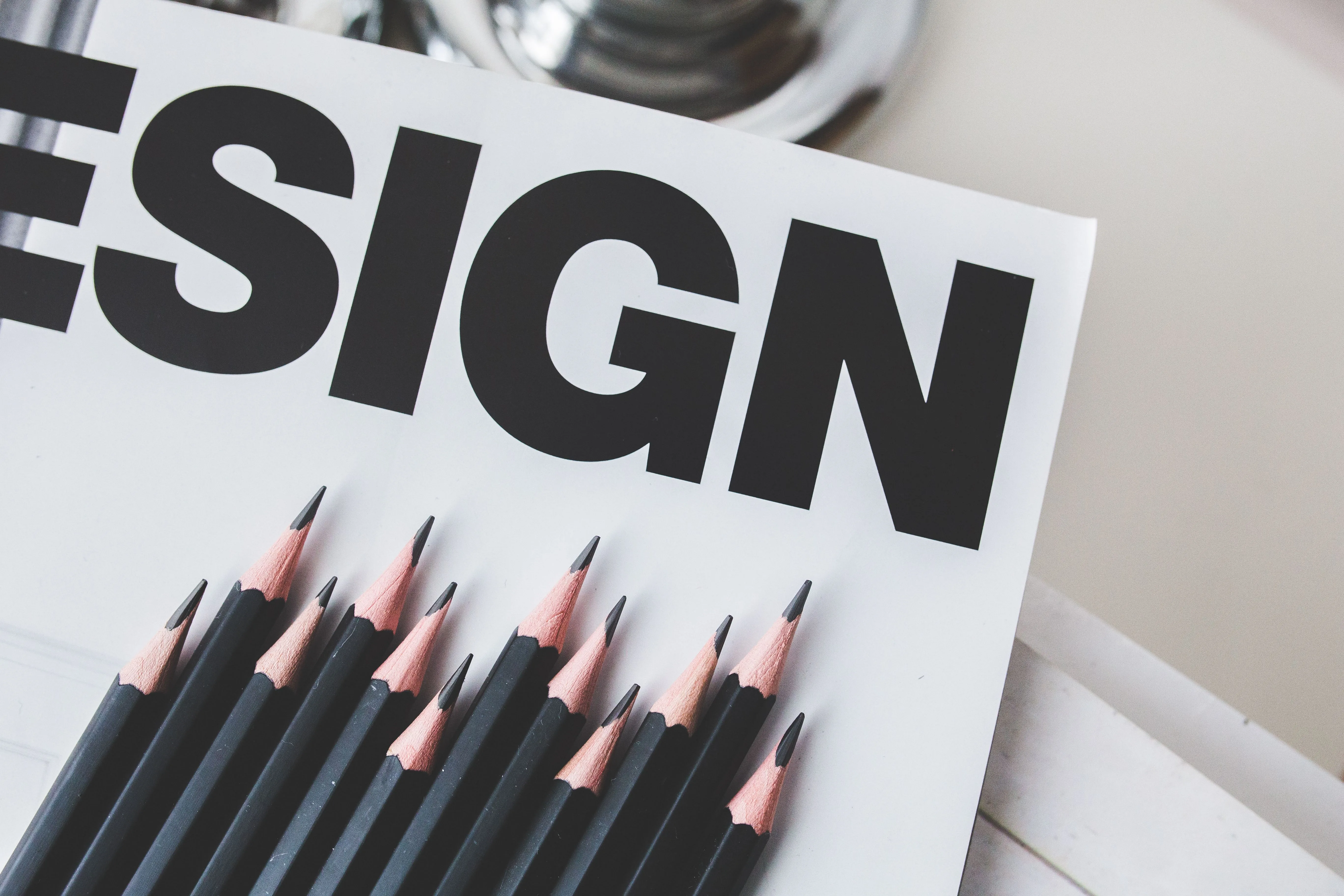 Mot design écrit sur une feuille blanche et des crayons à papier